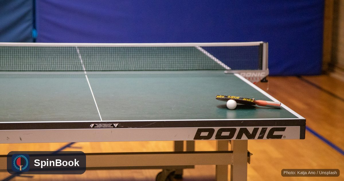 An empty table tennis table with a racket and ball left on it